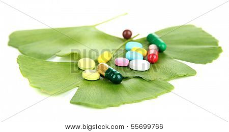 Ginkgo biloba leaves and pills isolated on white