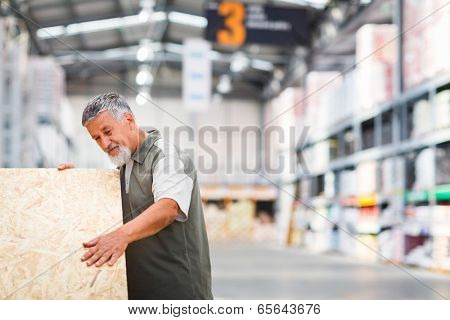 Man buying construction wood in a  DIY store for his DIY home re-modeling project