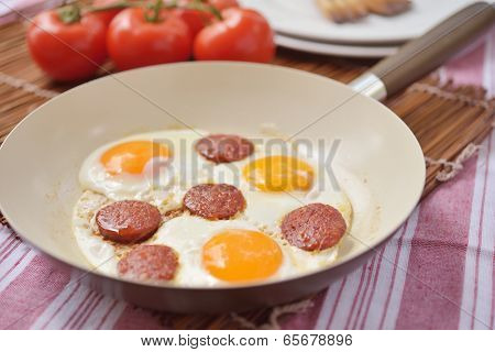 Fried eggs with sucuk in a pan