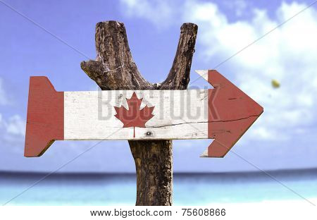 Canada wooden sign with a beach on background 