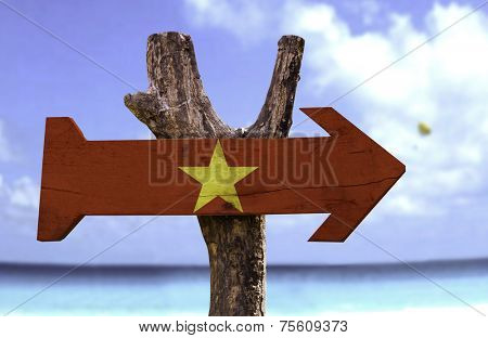 Vietnam wooden sign with a beach on background 