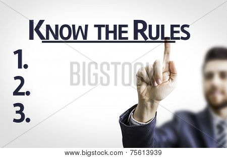 Business man pointing to transparent board with text: Know the Rules 