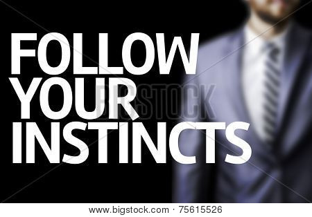 Follow your Instincts written on a board with a business man on background