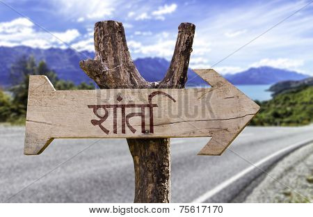 Peace (In Hindi) wooden sign with a road background
