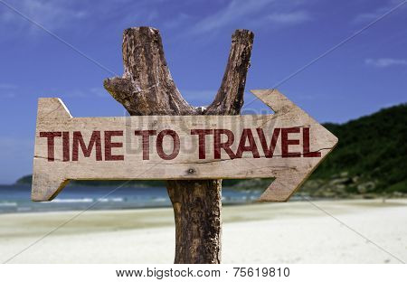 Time to Travel wooden sign with a beach on background