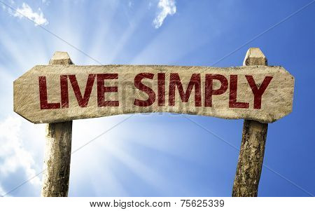 Live Simply wooden sign on a summer day