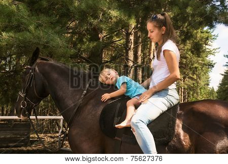 Kid With Mum Drive On Horse Top