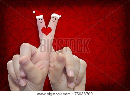 Concept or conceptual old vintage red pattern paper background with man and woman finger in love with Christmas hats and a heart painted, metaphor to family, couple, celebration, holiday, roamnce card