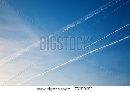 Airplane With Trail Against The Blue Sky