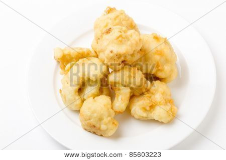Florets of cauliflower parboiled then dipped in batter and deep fried