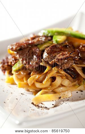 Japanese Cuisine - Udon with Beef and Avocado. Garnished with Cherry TOmato and Avocado