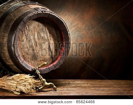 Still life: old wooden pin of beer and wheat on the table in the cellar.