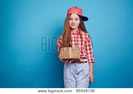 Little girl holding a box, tied with ribbon