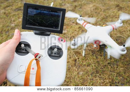 MOSCOW - MAR 11, 2014: Control panels in hand and quadcopter with propellers
