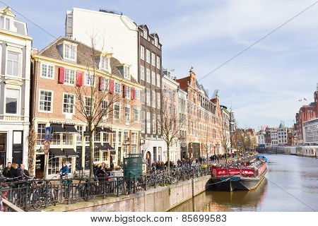 Tourists walking by a canal in Amsterdam