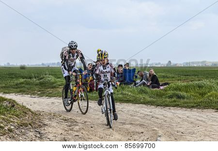 Amateur Cyclists Riding On A Cobblestoned Road