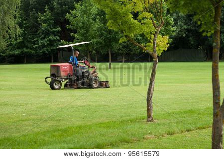 ZAPRESIC, CROATIA - JULY 09, 2015: Golf course worker mows the grass of a green in the early morning on a Novi Dvori golf course