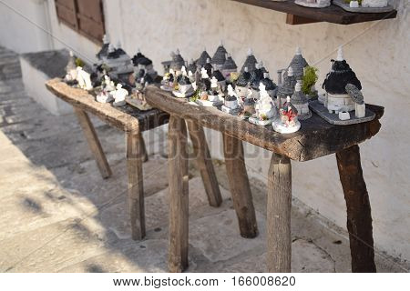 Souvenir of the traditional trulli houses on a wooden bench in Alberobello, Apulia, Italy
