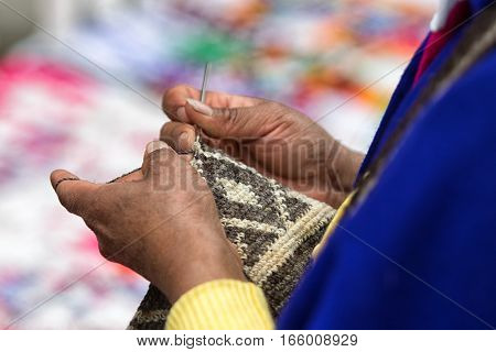 September 6, 2016 Silvia, Colombia: hands of a Guambiano woman knitting a shoulder bag