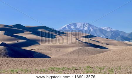 Sand dunes and snowy mountains on the background. Great Sand Dunes National Park and Preserve. Denver. San Luis Valley. Alamosa Saguache County Colorado. United States.