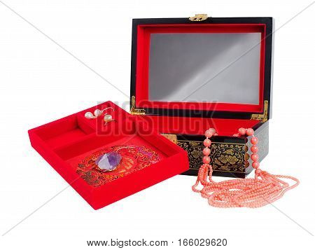 Picture of the opened jewel-box with red fit-out. Wooden jewel-box with pink coral bead necklace isolated on white background. Side view.