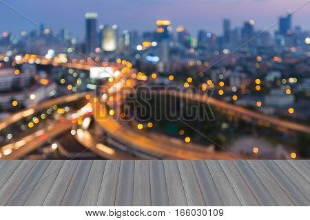 Opening wooden floor blurred bokeh lights highway intersection with city downtown background