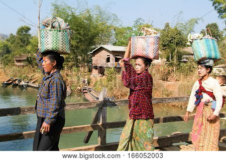Indein Myanmar - 15 January 2010: Woman carrying merchandise for the weekly market at Indein on Inle Lake in Myanmar