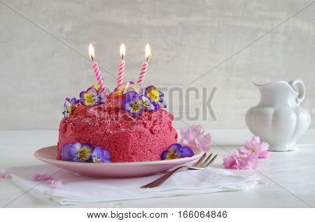 homemade birthday cake with pink buttercream and horned pansy