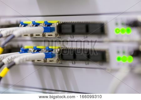 Equipment of radio base station close-up blue and yellow optic patch cords. Internet. Communication. Network