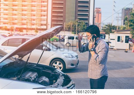 Young Asian Handsome Man Standing By The Broken Down Car