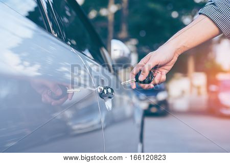 Men's hand using key unlock doors car