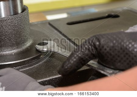 Craftsman pulling metal screw with wrench - close up