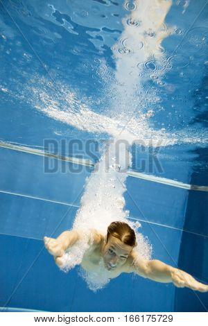 a young man is jumping into the water from a diving plattform