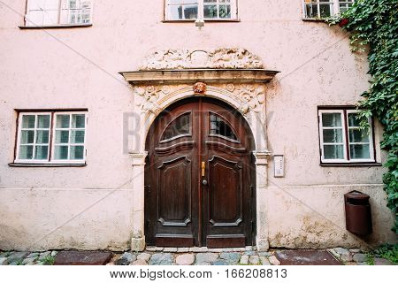 Riga, Latvia. Old Wooden Brown Door Of The Portal, Decorated By Molding On Facade Of Ancient Building On Torna Street In Old Town In Summer Day.