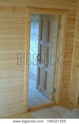 Opened door inside new built wooden house vertical view