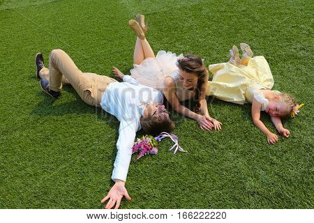 The beautiful young people lying on the grass. They are happy