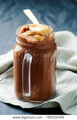 Peanut Butter Chocolate Overnight Oats in to the jar.selective focus