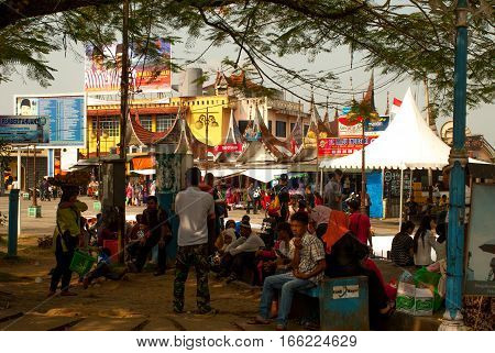 Bukittinggi, Indonesia - August 23, 20015 - People resting in the shade on square