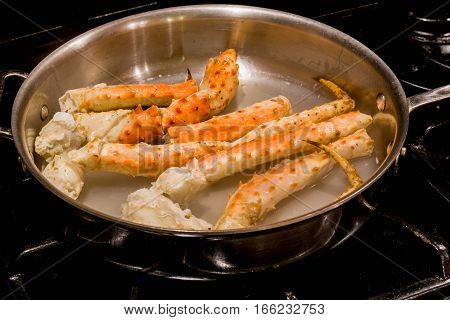 Red crab legs being cooked in a pan