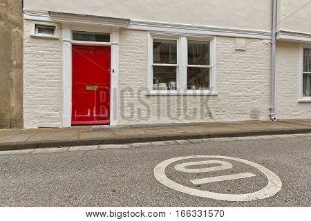 Red door in white brick wall, England