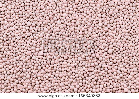 Pink composite mineral fertilizers granules closeup. Background