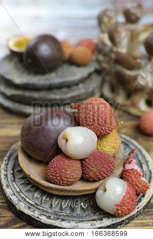 Tropical fruits - Lychees and Passion Fruit or Maracuya on wooden background
