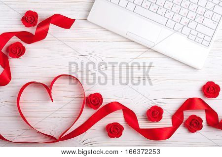 Valentines background with red heart laptop and roses. Valentines Day greeting card. Female workplace. Top view
