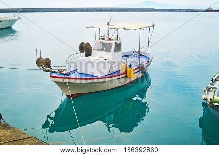 fishing boat reflected on sea at Kalamata port Peloponnese Greece