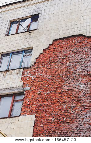 Old High-rise Building With Broken Windows, Crumbling Walls Covered With Cracks And Scratches