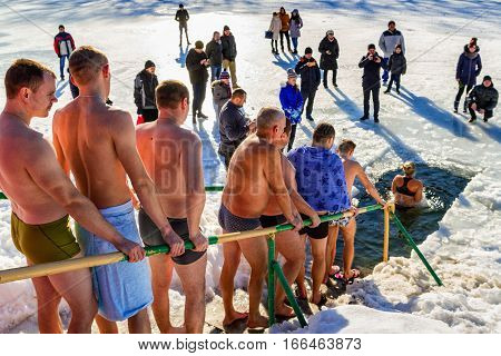 Uzhgorod Ukraine - January 19 2017: Greek-Catholic parishioners by orthodox tradition dip in the icy river during the Epiphany celebration. Epiphany Day completes the Christmas-New Year festivities cycle in Ukraine.