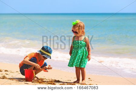 kids play with sand on summer beach, family beach vacation