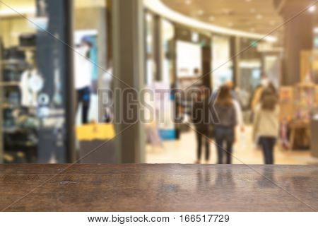 Selective foucus on Empty wooden table with the shopping mall have laday shopping background. For display or montage your products.