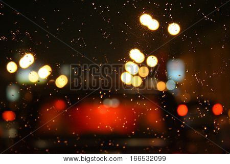 Beautiful background with bokeh and water drops on the glass night