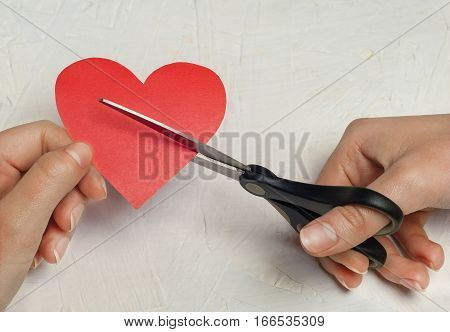 Close up of paper broken heart on white wooden background
